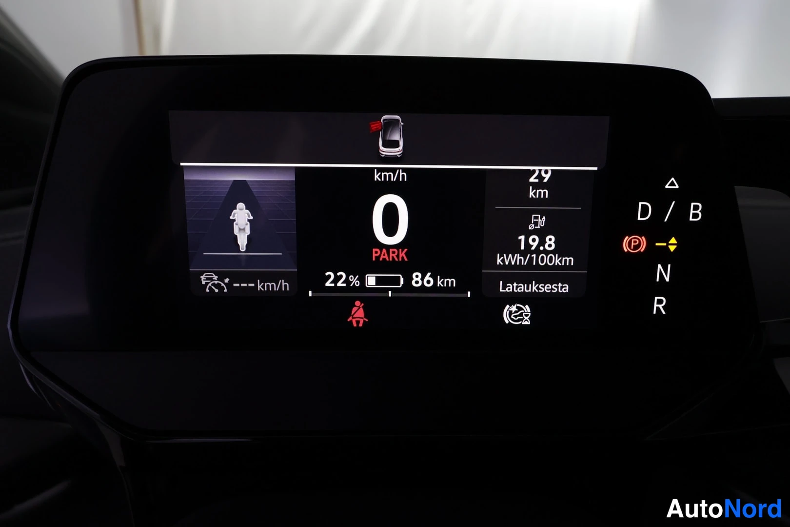Yksityiskohta: Digitaalinen mittaristo: nopeus 0 km/h, PARK, akun lataus 22 % ja toimintamatka 86 km, kulutus 19,8 kWh/100 km, Latauksesta 29 km.