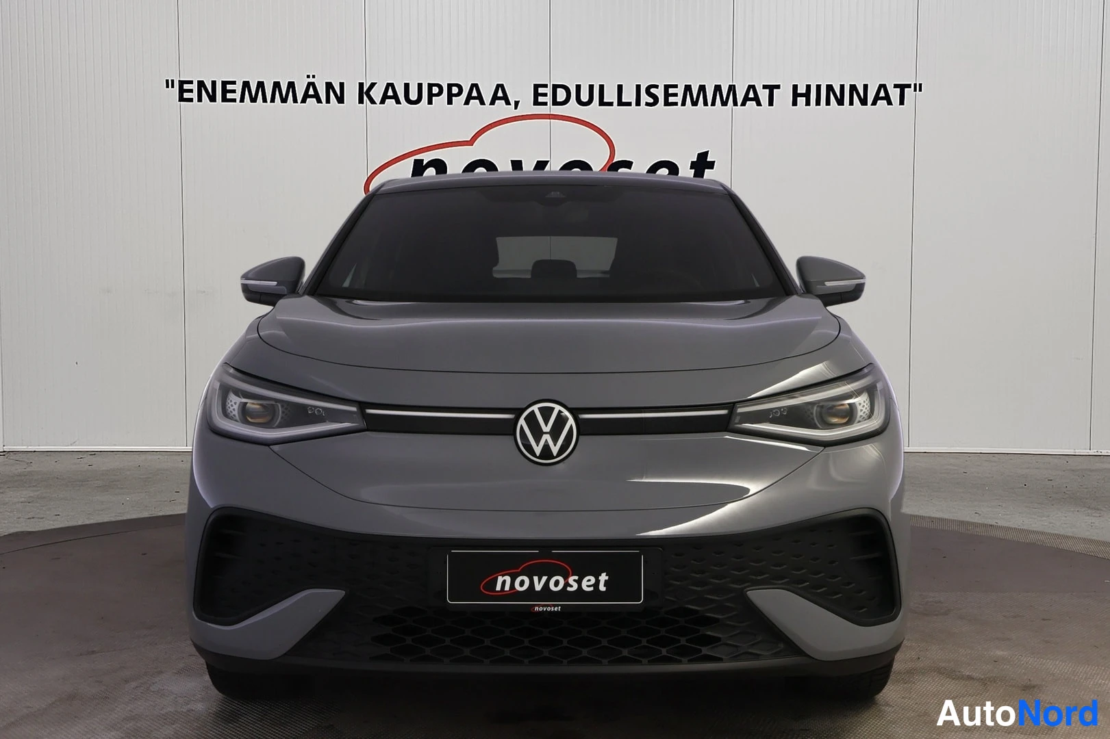 Edestä: Suora etukuva harmaasta autosta, keulakilpi, LED-ajovalot ja musta etupanssari kuvassa.