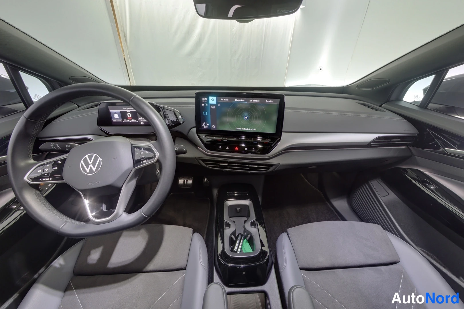 Muu: Ohjaamosta yleiskuva: Volkswagen-ohjauspyörä, kosketusnäyttö radiovalikolla ja kaksi etuistuinta.