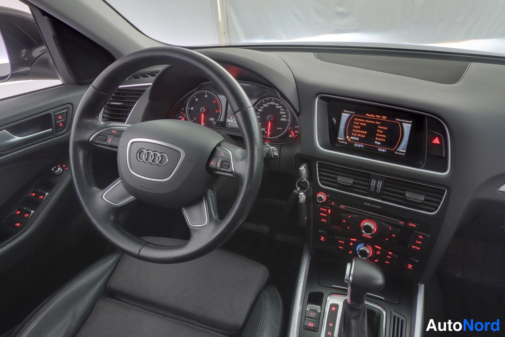 Muu: Audi Q5:n ohjaamon kuljettajan puoli: ratti, mittaristo, keskikonsolin näyttö ja automaattivaihteen valitsin.