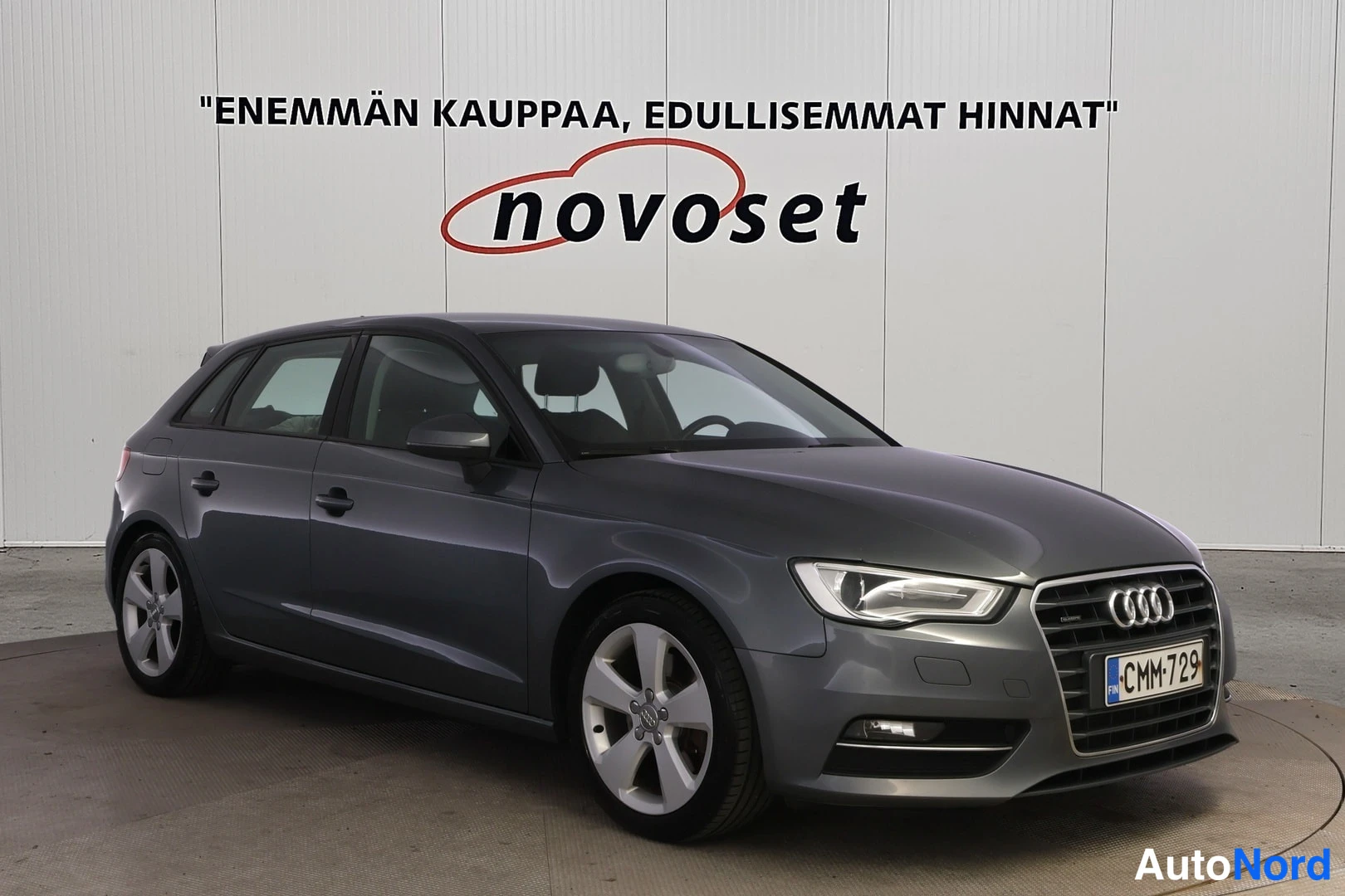 Etuviisto, nokka oikealle: Tummanharmaa Audi A3 Sportback etuviistosta oikealta, etuswinga ja kylki näkyvissä, rekisteritunnus.