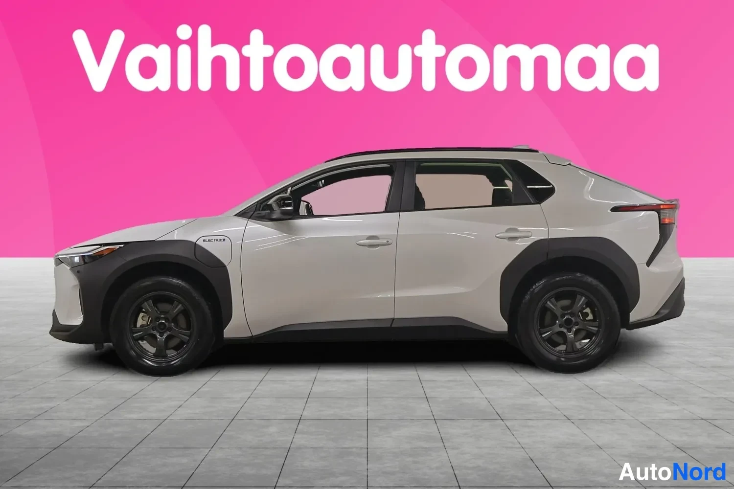 Sivulta: Toyota bZ4X -sähköauto vaaleanbeige-yllä sivusta kuvattuna, tummat pyöränkaaret ja tummat vanteet.