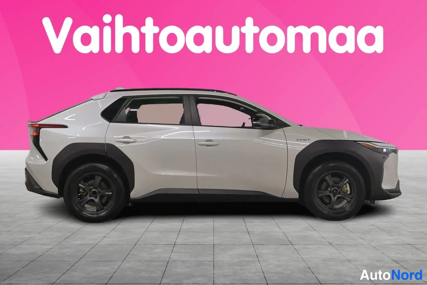 Sivulta: Auton oikea sivu täydellisenä: vaalea beigeToyota bZ4X, mustat korokkeet ja tummat vanteet.