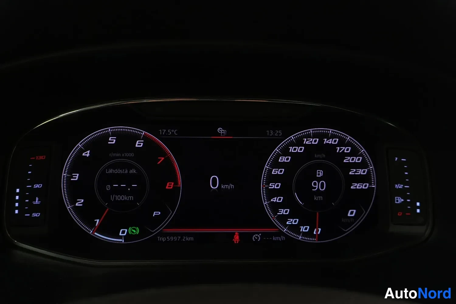 Muu: Auton digitaalinen mittaristo pimeässä: nopeusmittari 0 km/h, matkamittari 5997,2 km, lämpötila 17,5 °C.