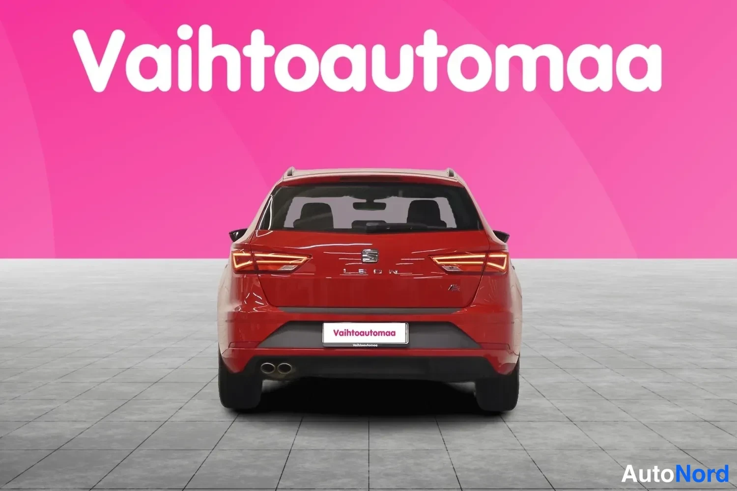 Takaa: Punaisen Seat Leon ST -farmariauton takaosa suoraan takaa, LEON-teksti ja takavalot näkyvät.