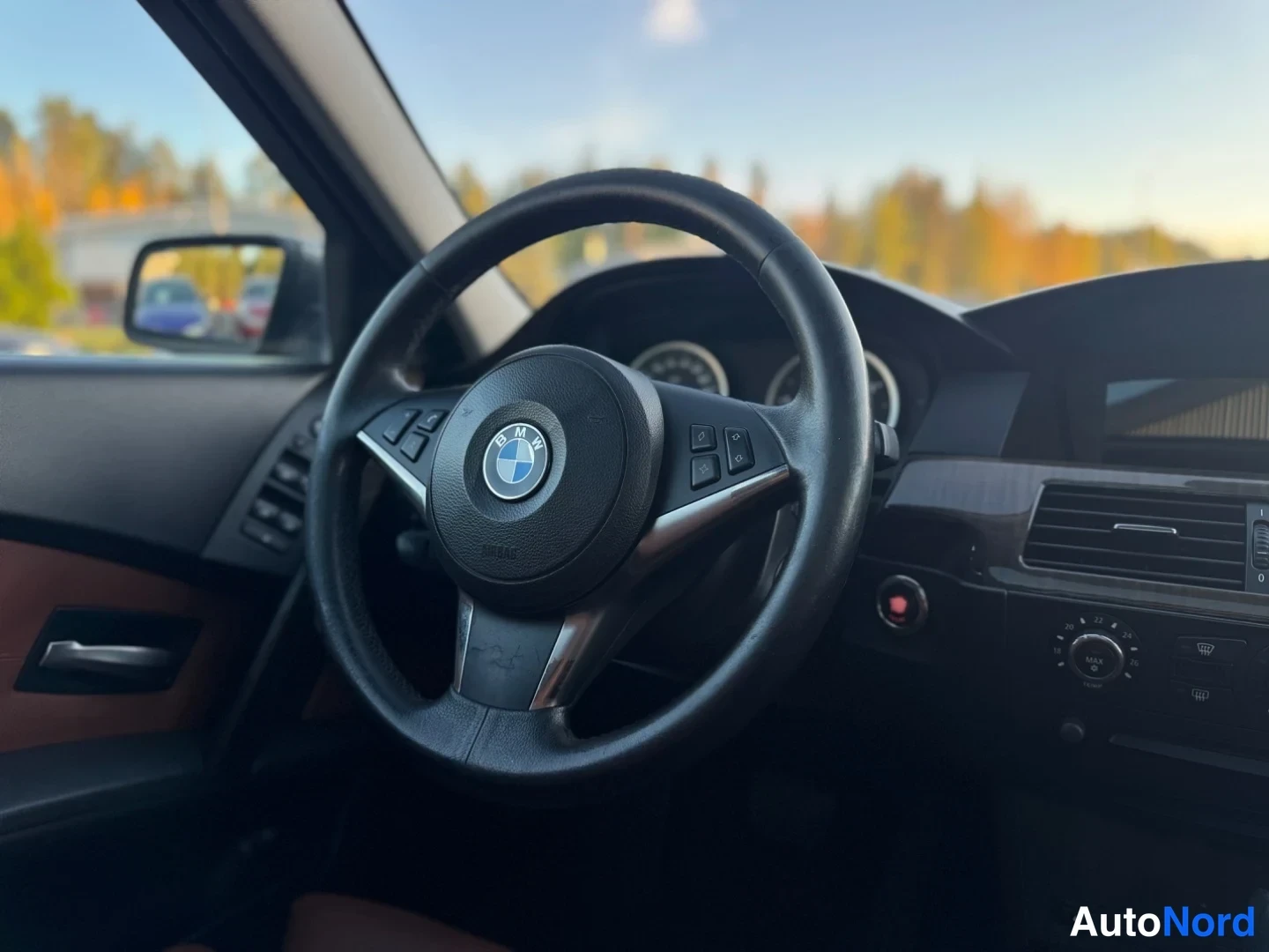 Takaa: Lähikuva BMW-ohjauspyörästä ja mittaristosta sisällä autossa.
