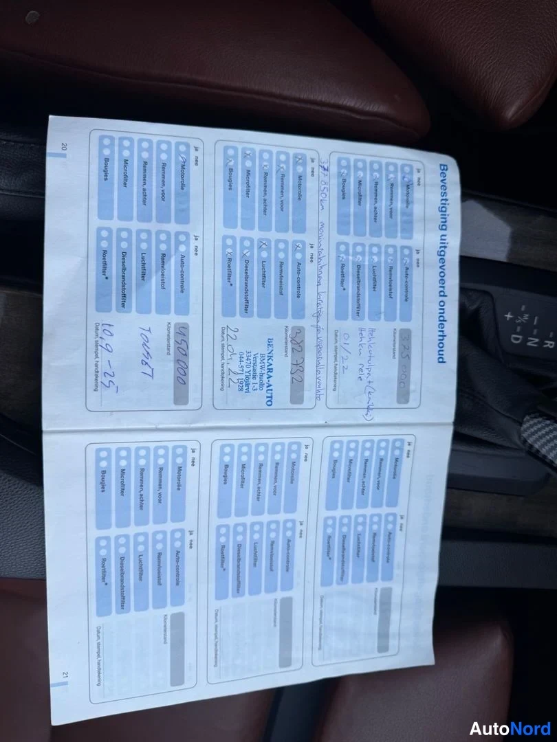 Muu: Huoltokirjan sivut, joissa käsinkirjoitetut merkinnät ja ATZ Autohus AD leima, kuvattuna auton istuimella.