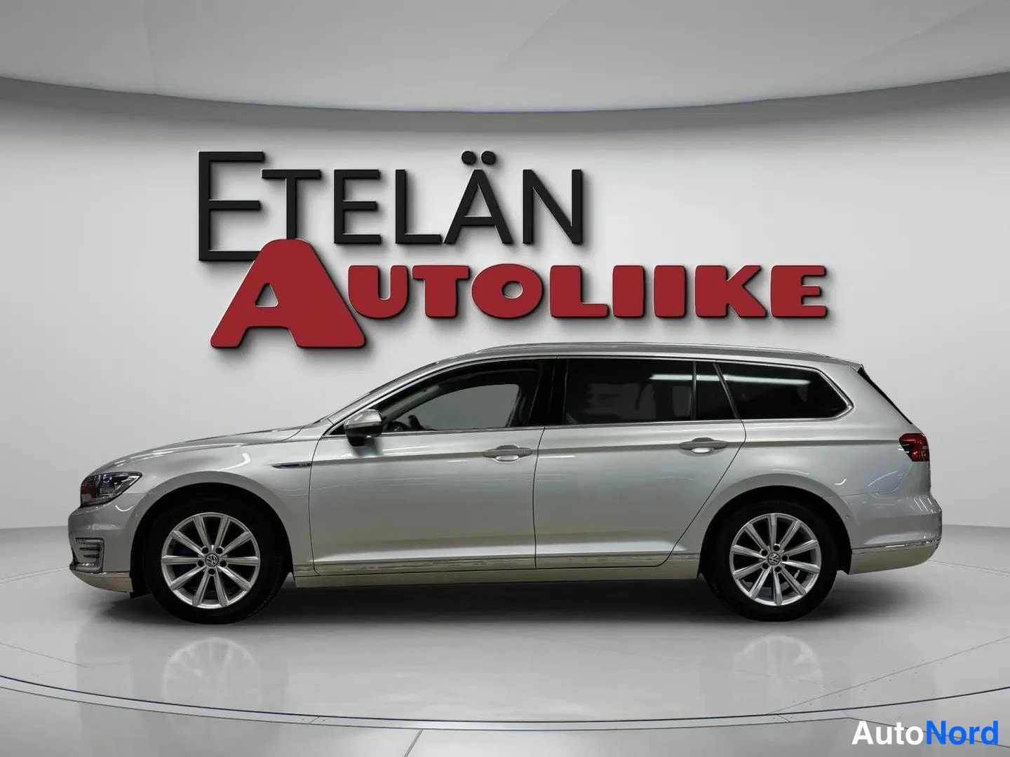 Sivulta: Hopeanvärinen Volkswagen Passat Variant vasemmalta sivulta kuvattuna, auton kylki ja ovien muodot näkyvät studio-tilassa.