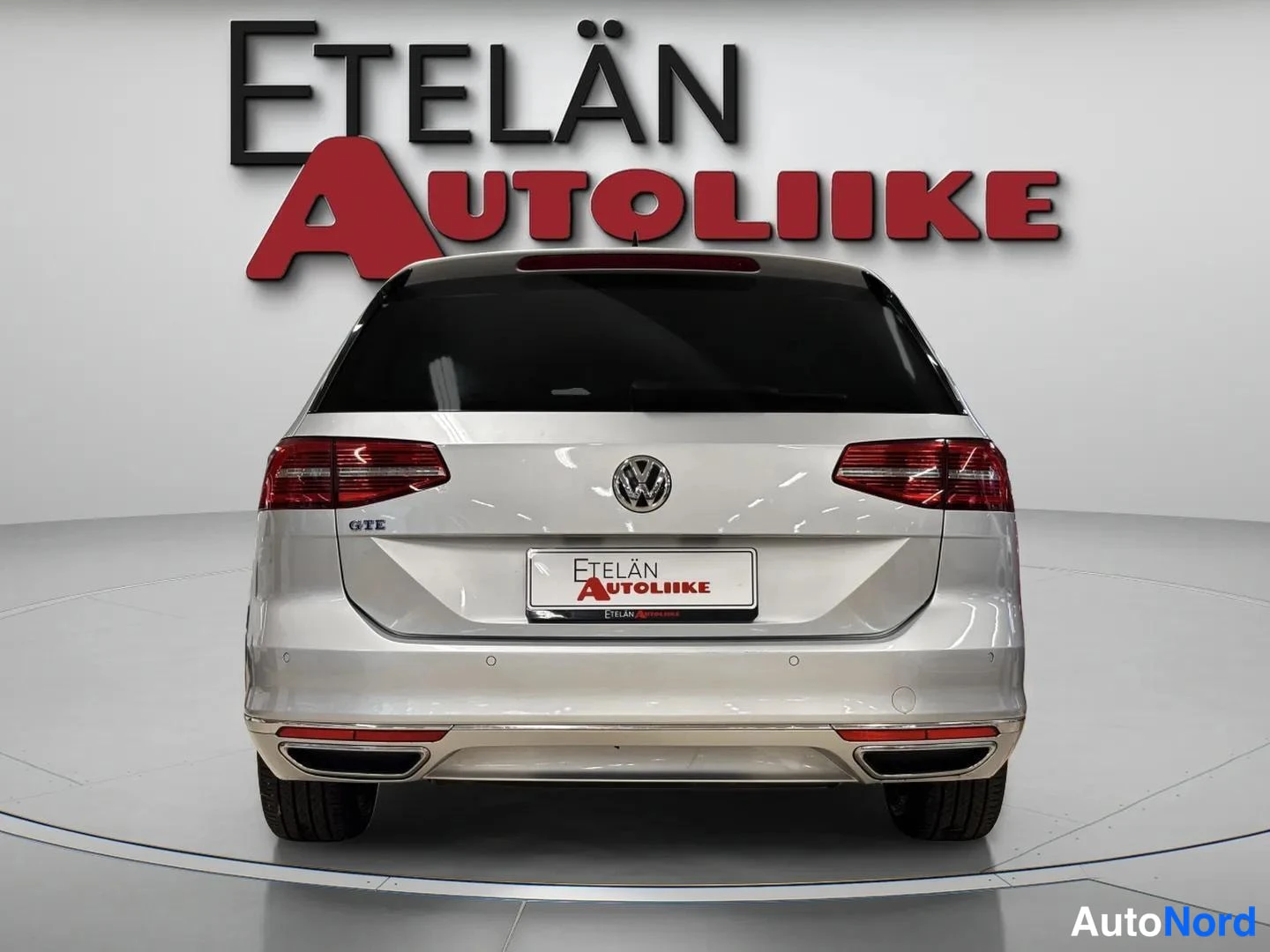 Takaa: Hopeanharmaan farmariauto takanäkymä; punaiset takavalot, VW-merkki ja takapuskuri näkyvät suoraan taapäin.