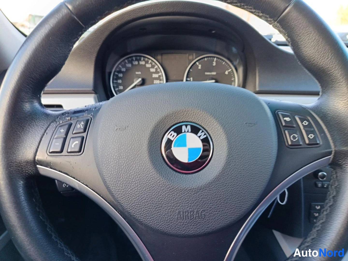 Etuviisto, nokka vasemmalle: Lähikuva BMW-ohjauspyörästä, taustalla osa kojelaudasta.