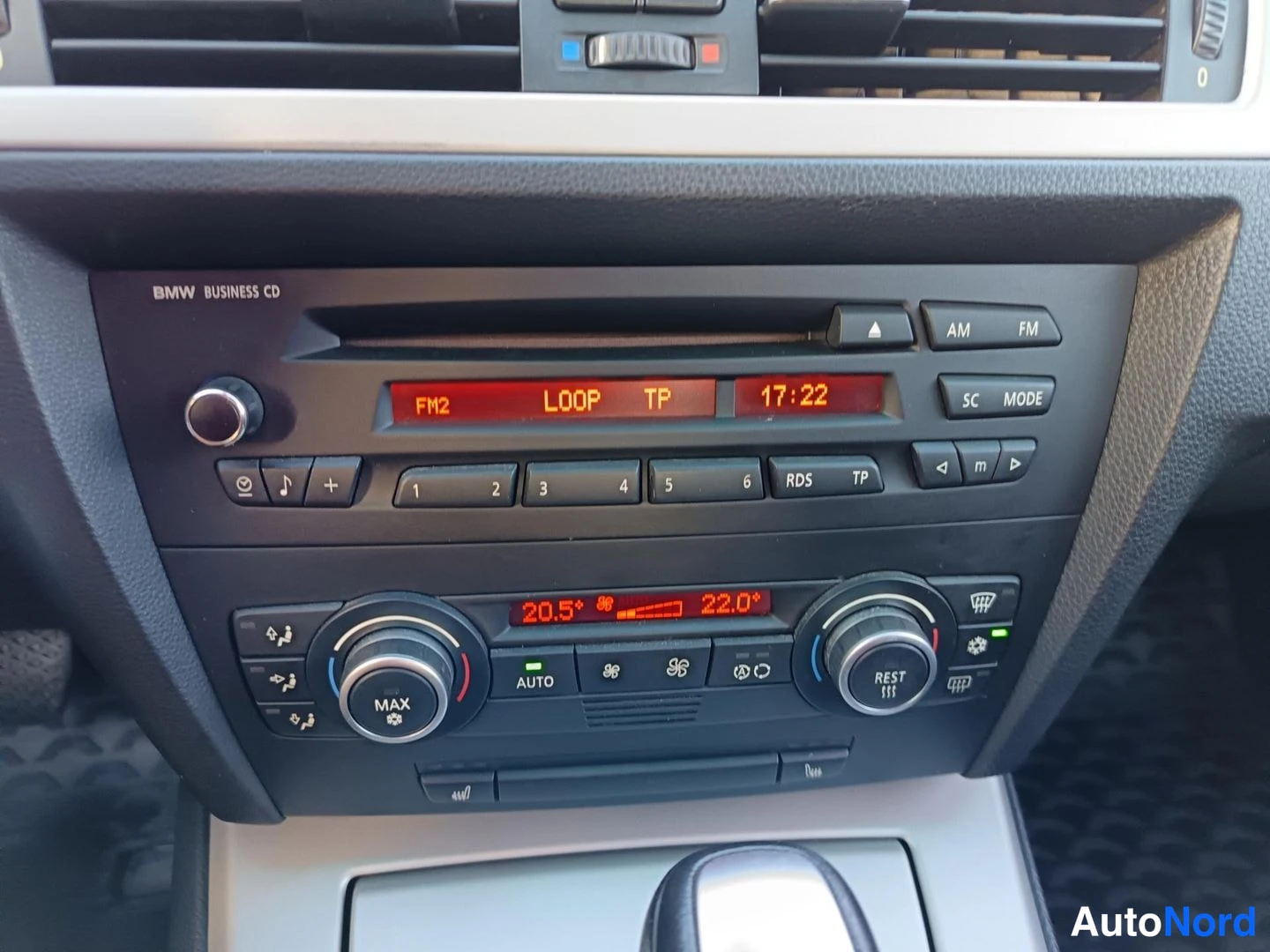Muu: Kojelaudan keskusta: BMW Business CD -radiosoitin ja kaksivyöhykeilmastointi, näytöllä FM2, LOOP TP ja kello 17:22.