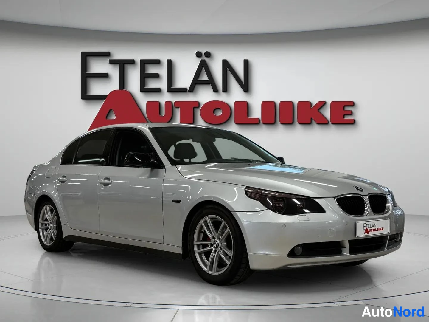 Etuviisto, nokka oikealle: Hopeanharmaa BMW 520i -sedan etuokolikuvassa oikealta, etunäkymästudio.