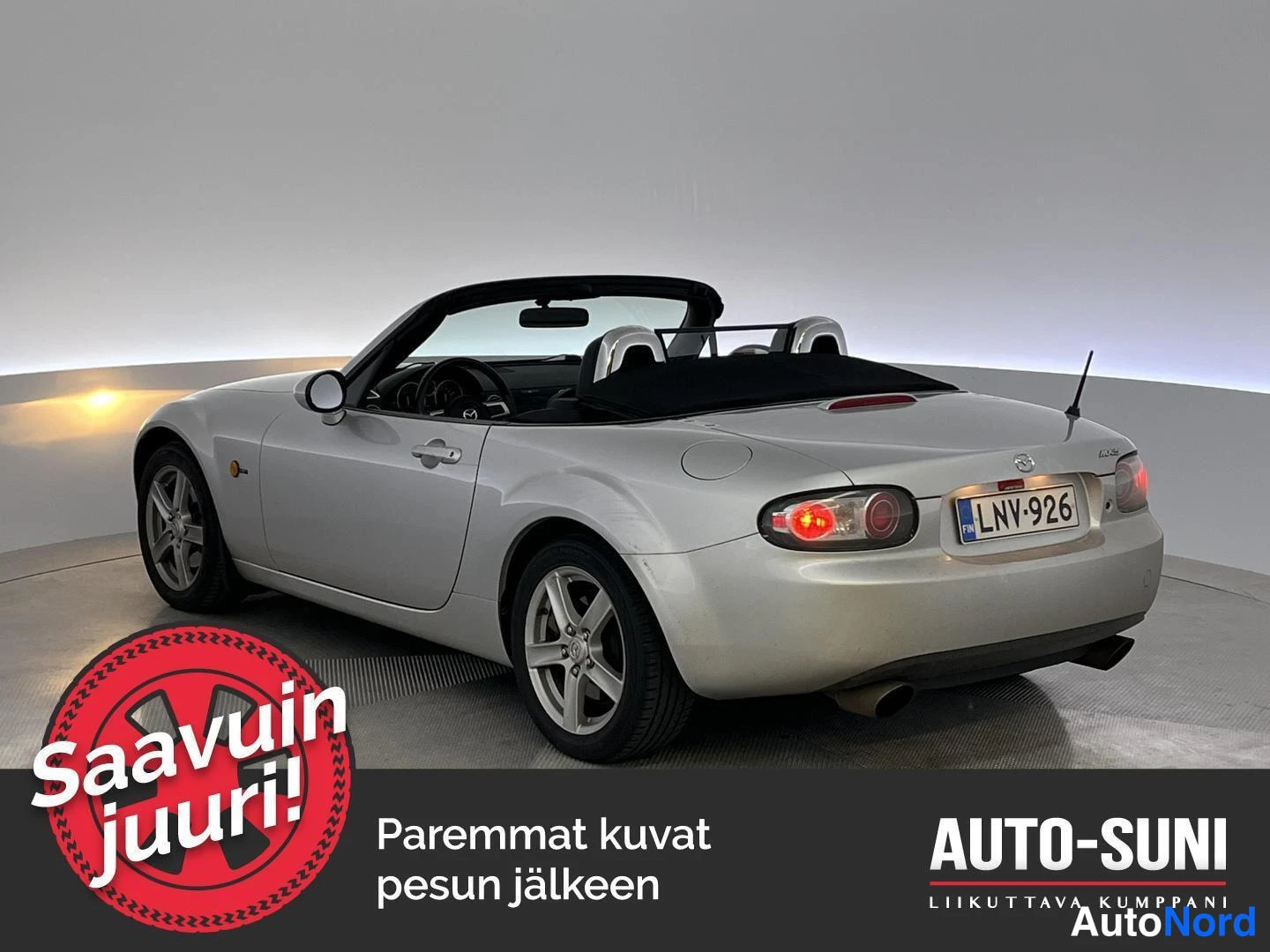 Takaviisto: Hopeanvärinen avo-Mazda MX-5 takakulmasta vasemmalta, pehmeä katto auki, rekisteritunnus.