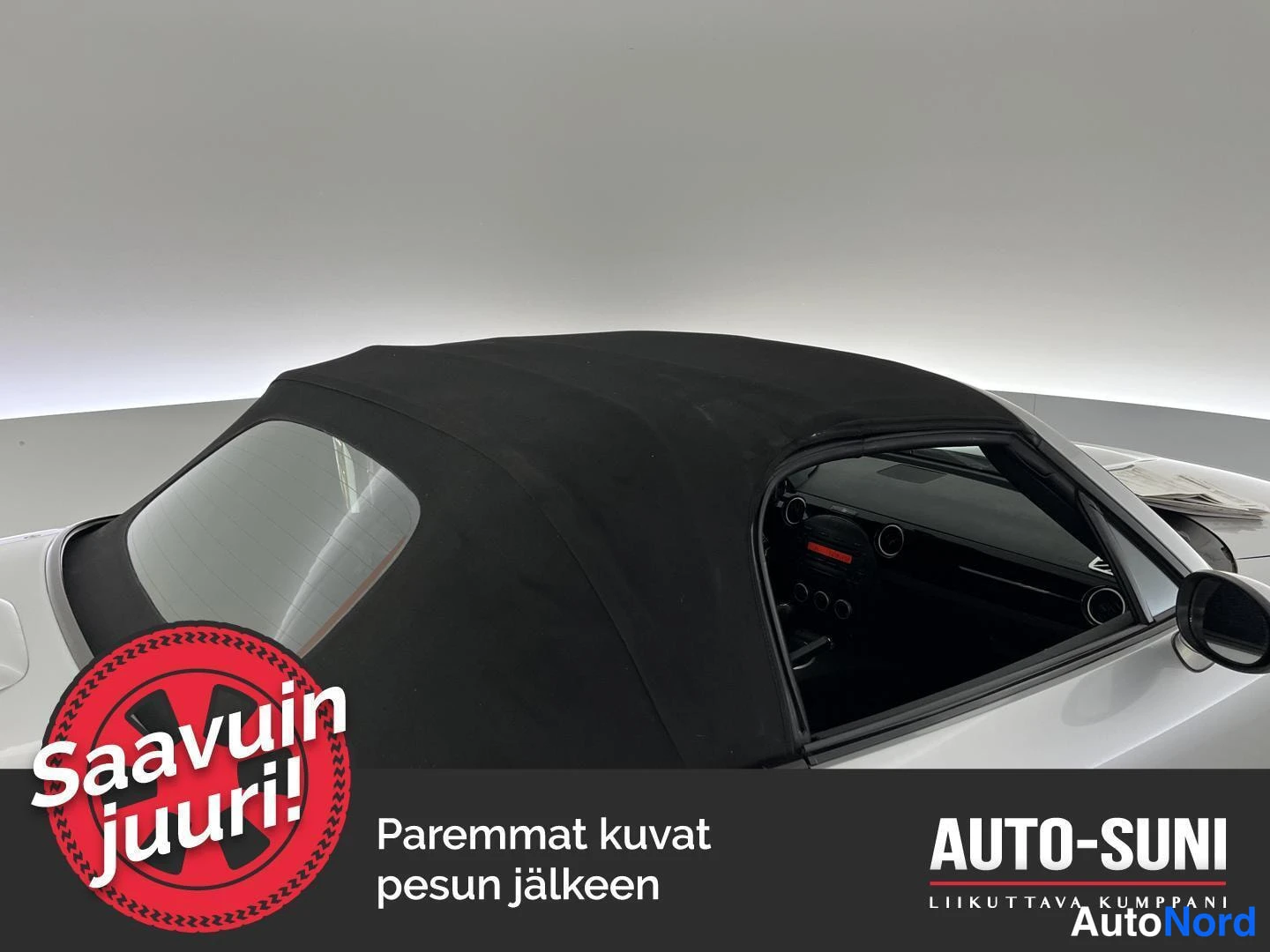 Etuviisto, nokka oikealle: Mazda MX-5:n musta pehmeä katto kiinni, kattoluukku ja sisusta näkyvät.