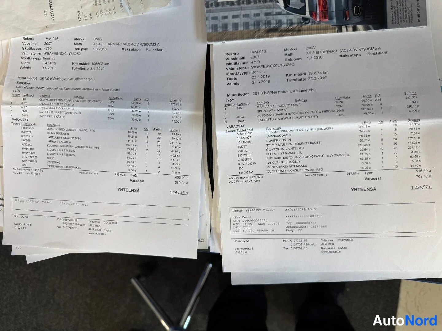 Muu: Kaksi työtilauskuittia ylhäältäpäin kuvattuna, joissa näkyy BMW X5 4.8i FARMARI (AC) huoltotöitä ja varaosia, yhteissummat 1 145,25 e ja 1 224,97 e.
