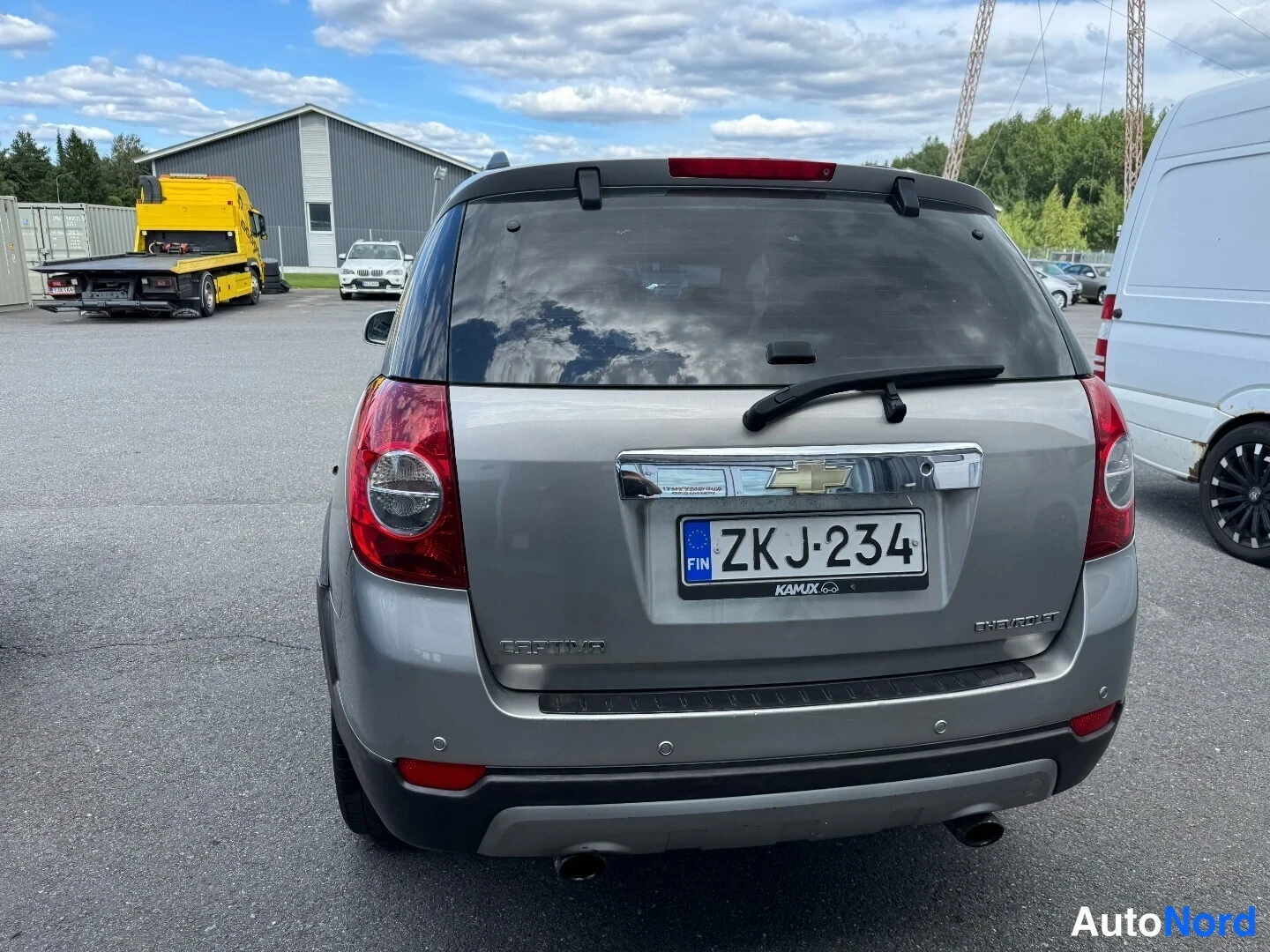 Takaa: Chevrolet Captivan takaosa suoraan takaa; rekisterikilpi, harmaa koria, kattospoileri ja kaksi pakoputkea näkyvät.