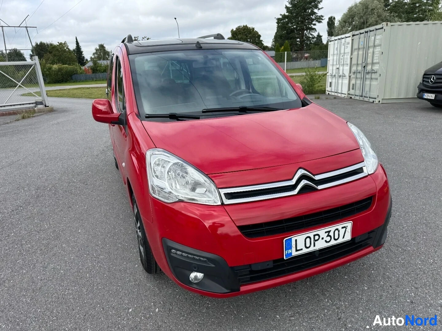Etuviisto, nokka oikealle: Punainen Citroen Berlingo -pakettiauto edestä oikealta kuvattuna, rekisterikilpi.