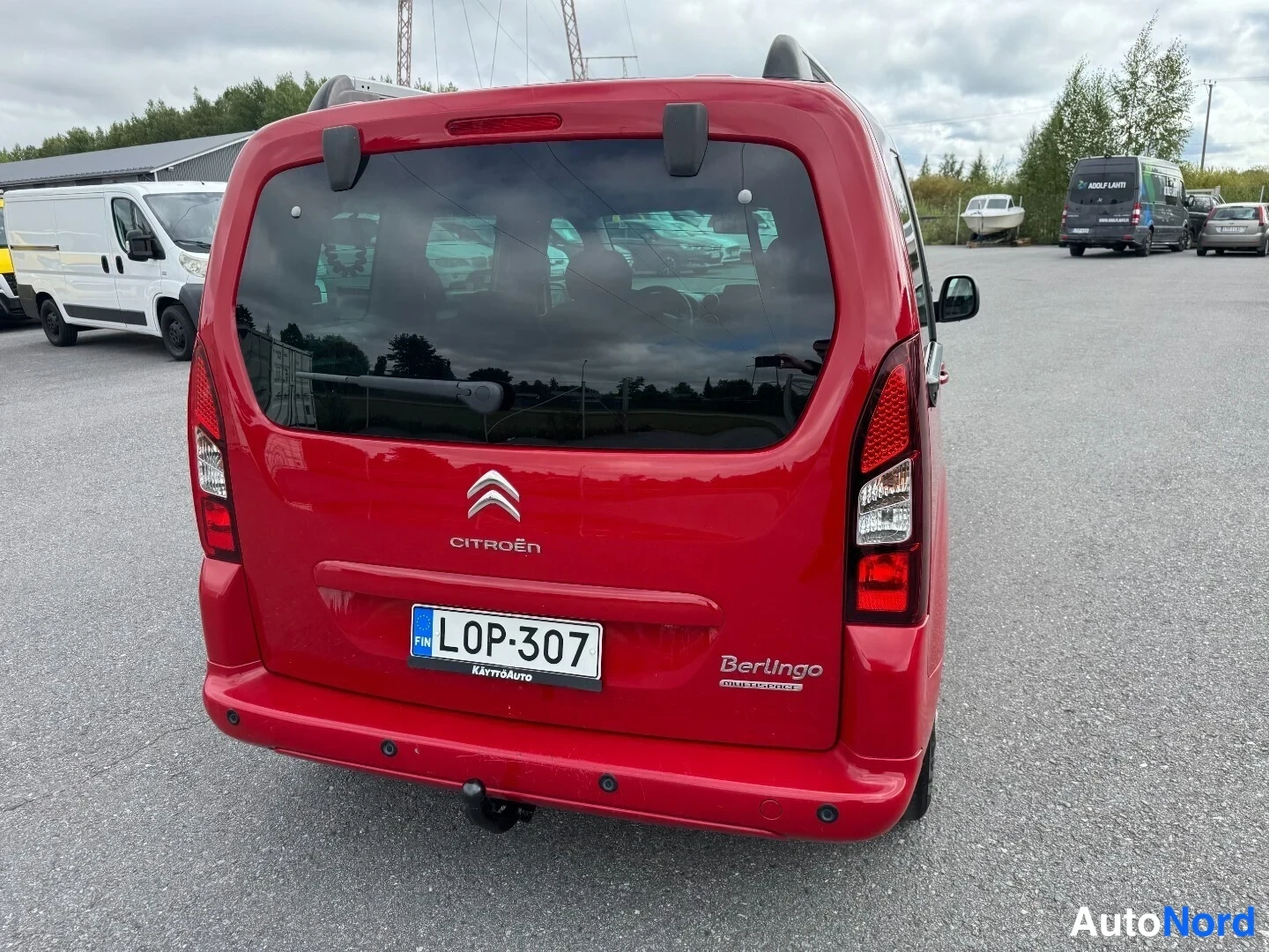 Takaa: Punaisen Citroën Berlingon takaosa suoraan takaa, Citroën-merkki, Berlingo Multispace -teksti ja rekisteritunnus.