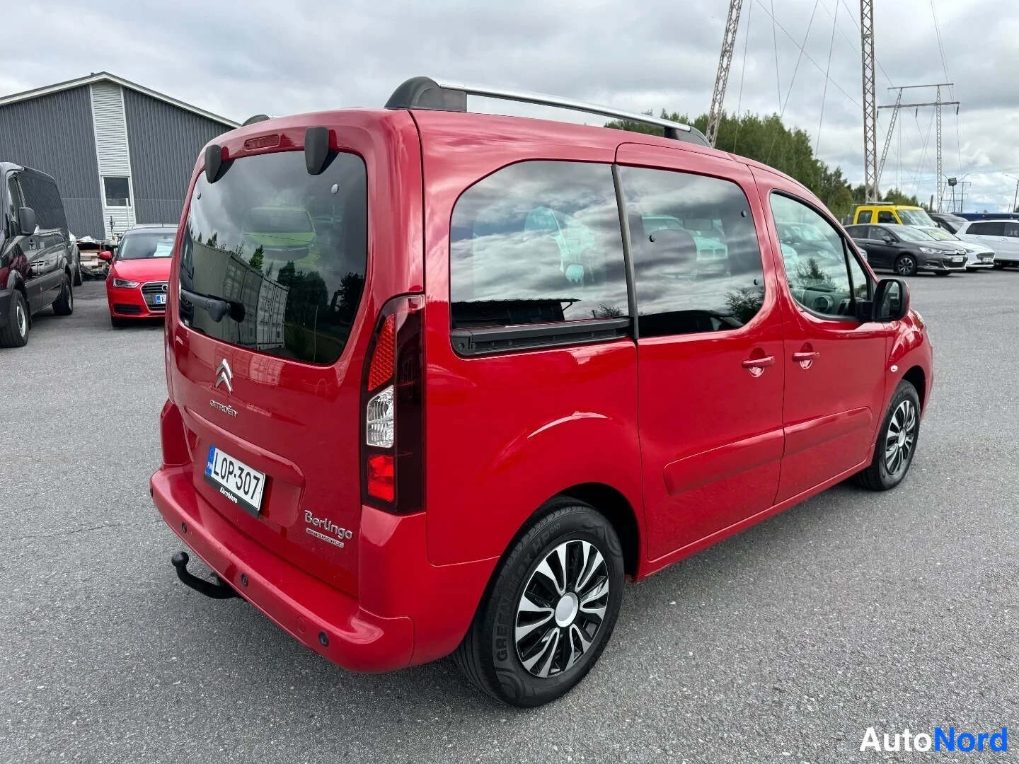 Takaviisto: Punainen Citroën Berlingo takaa ja oikealta sivulta; rekisterikilpi, kattokiskot ja hopeavanne näkyvät.
