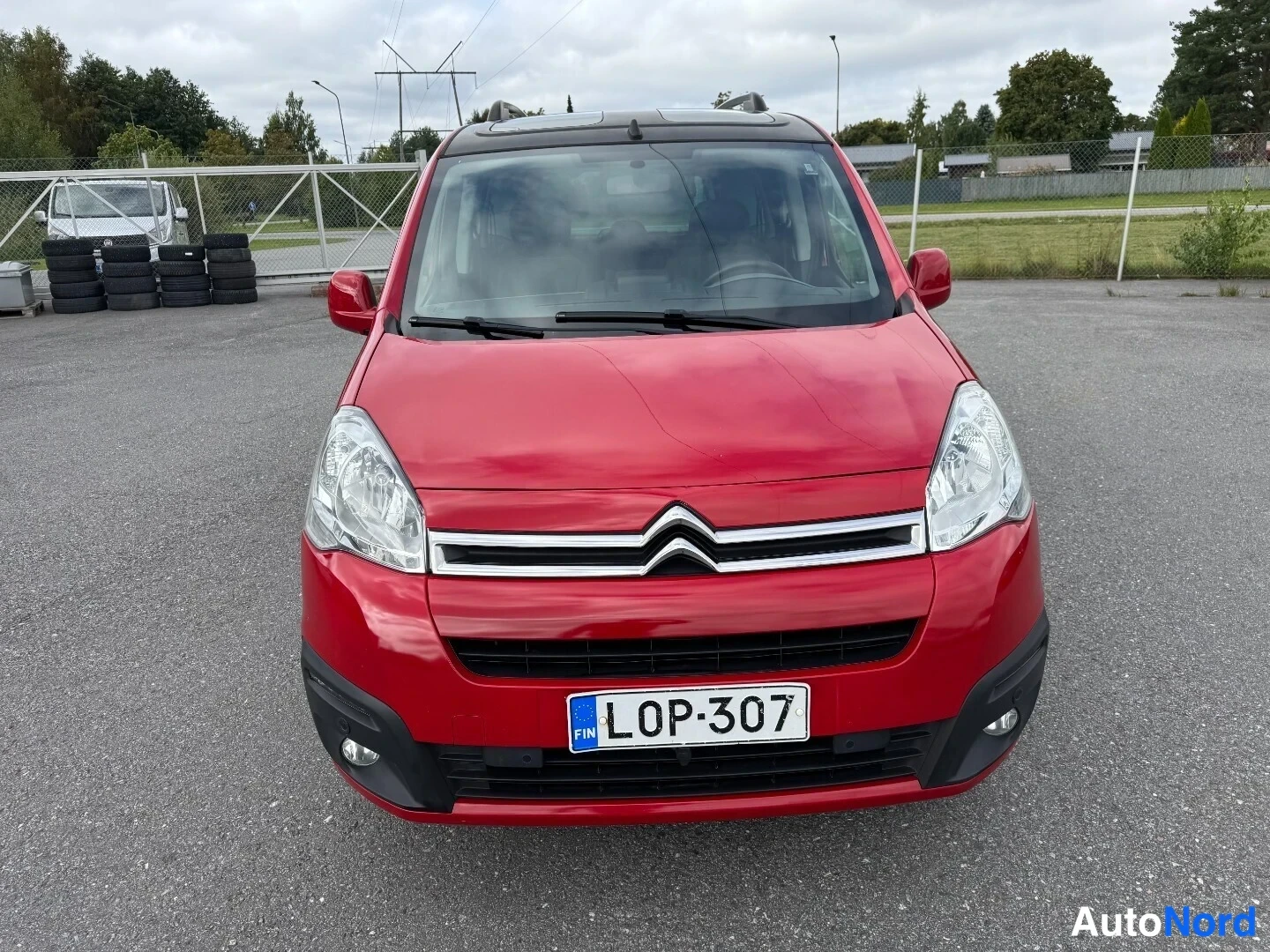 Edestä: Punaisen Citroën Berlingon etupäät edestä kuvattuna, rekisterikilpi.