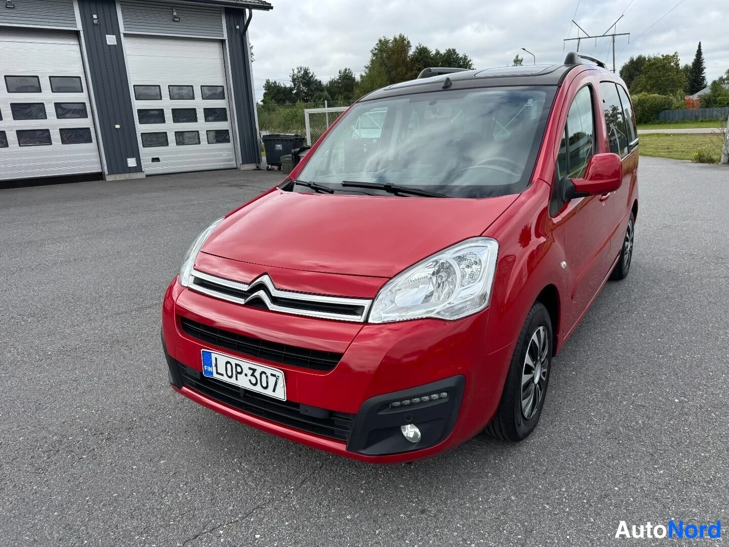 Etuviisto, nokka vasemmalle: Punaisen Citroën Berlingon keula ja oikea kylki kolmanneltplä kuvattuna, nokka vasemmalla, rekisterikilpi.