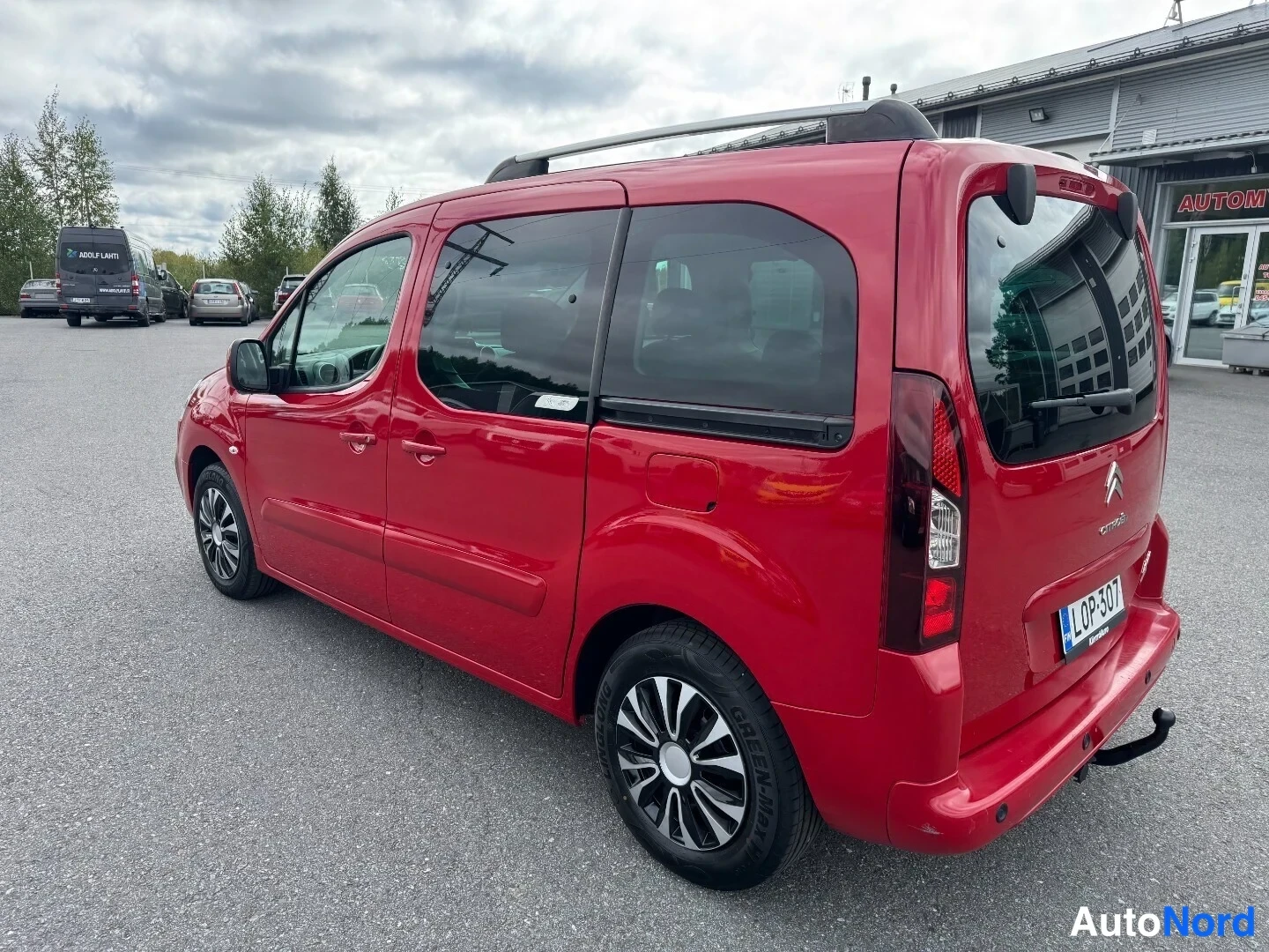 Takaviisto: Punaisen Citroën Berlingon takanasokulma, rekisteritunnus ja vetokoukku näkyvissä.