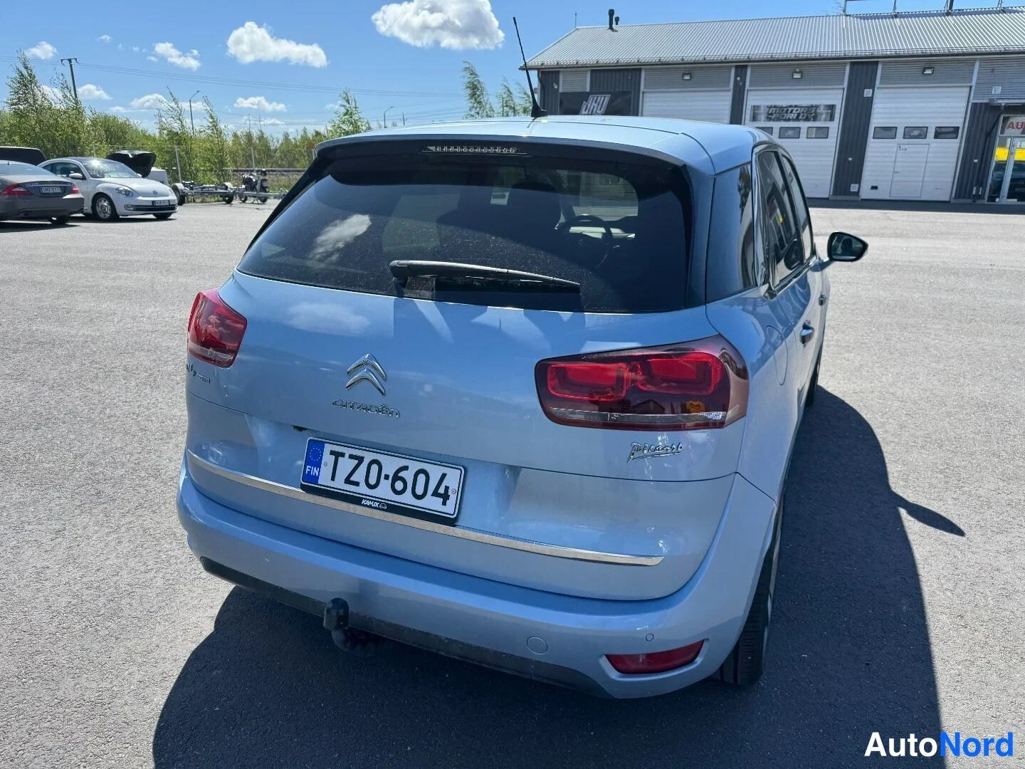 Takaa: Vaaleansininen Citroen C4 Picasso suoraan takaa kuvattuna, rekisterikilpi TZ0-604, takalasinpyyhkijä ja vetokoukku näkyvissä.