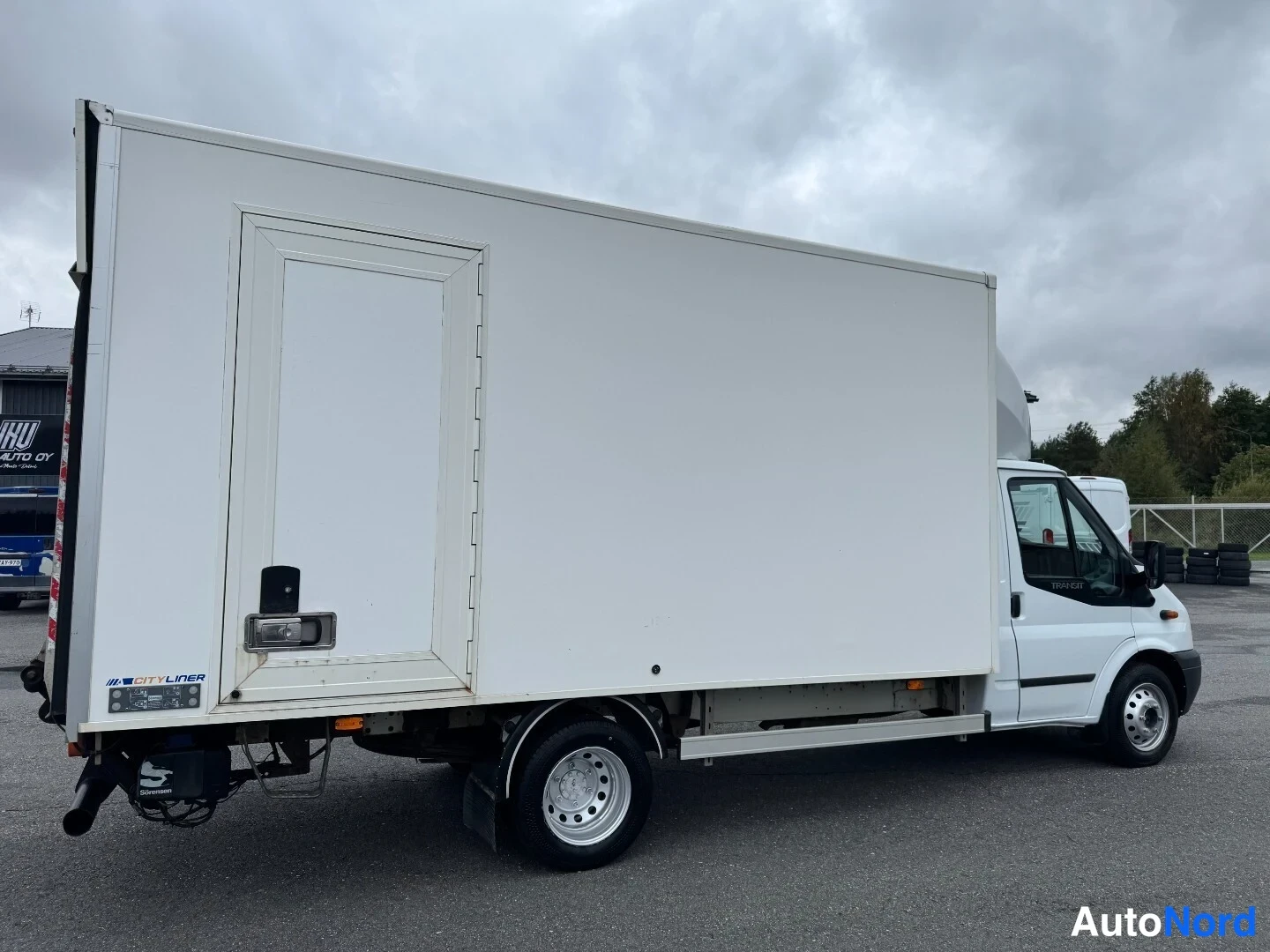 Sivulta: Ford Transit -kuorma-auto valkoisella Cityliner-lavalla sivusta kuvattuna.