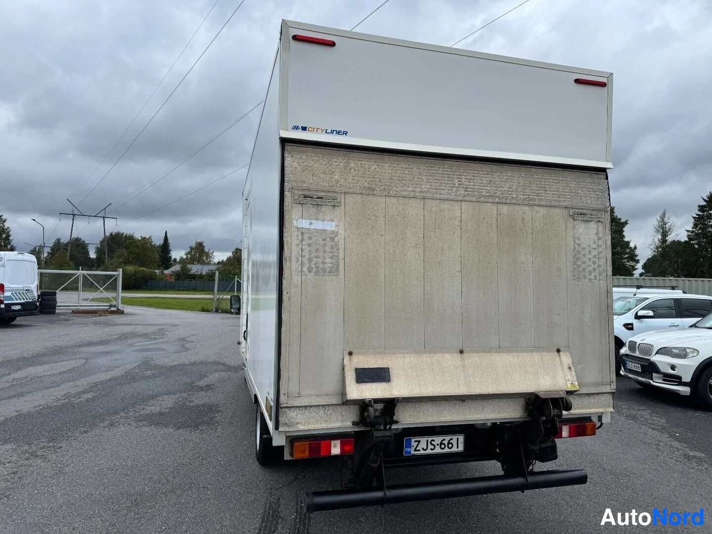 Takaa: Pakettiauton perä takaa päin, valkoinen Cityliner-taustalevy, pölyinen takapaneeli ja rekisterikilpi.