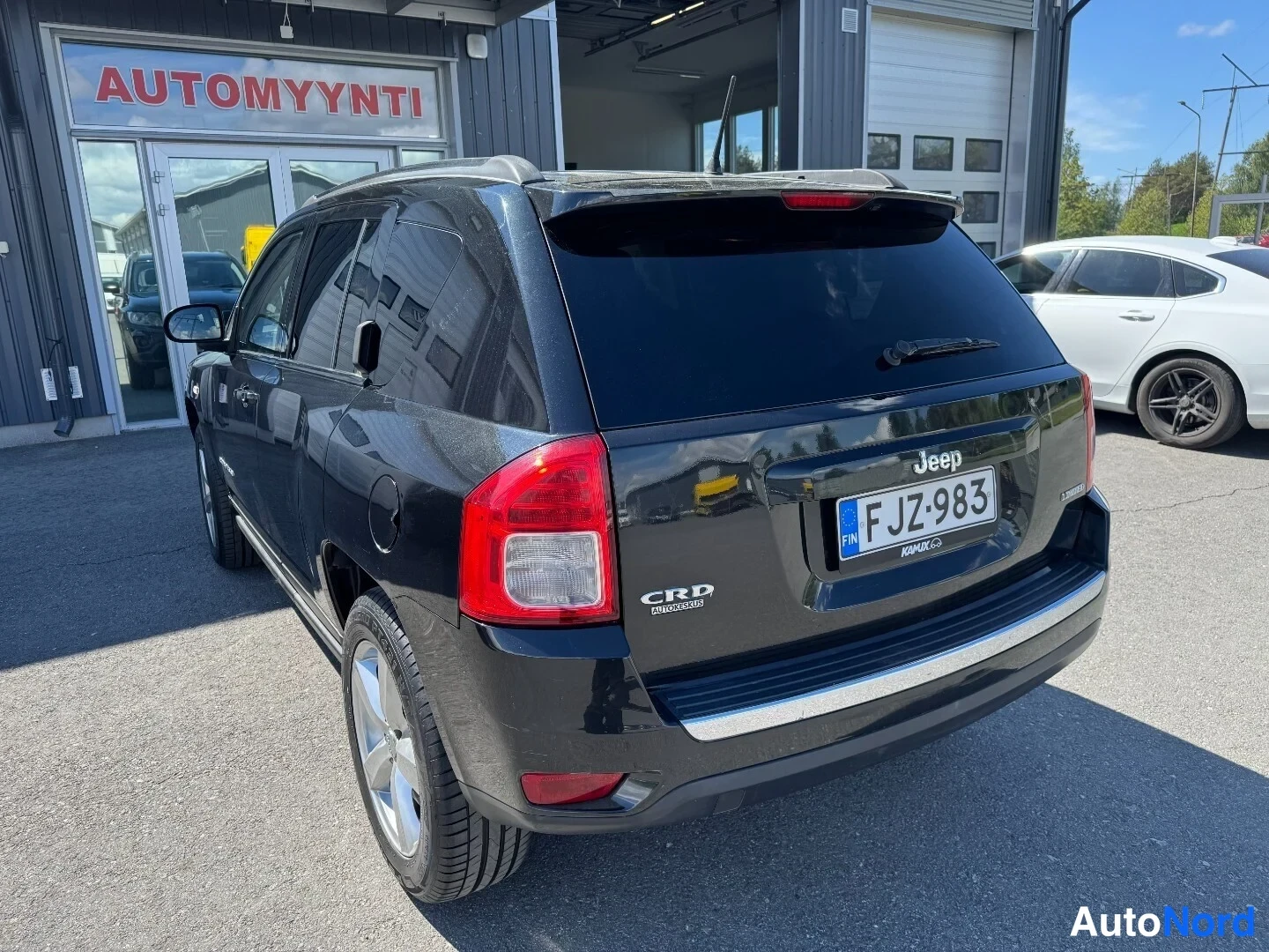 Takaviisto: Musta Jeep Compass takaa kuvattuna, rekisterikilpi, CRD-tunnus ja Jeep-merkintä takaluukussa.