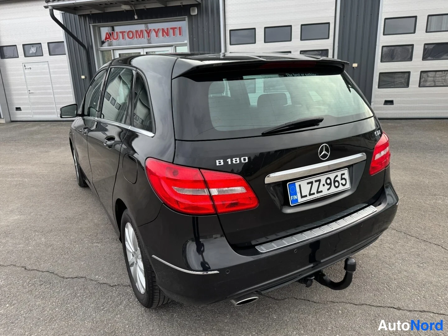 Takaviisto: Mustan Mercedes-Benz B 180:n takaosa vinystä, B 180 -merkintä ja -kilpi.