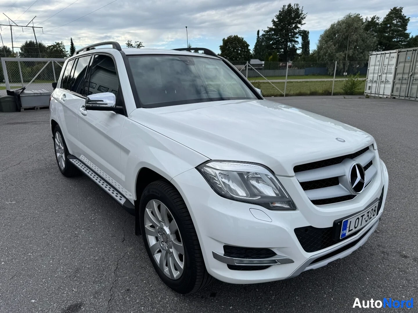 Etuviisto, nokka oikealle: Mercedes-Benz GLK:n etukulmakuva oikealta, valkoinen koriväri, etusäleikkö ja Mercedes-tähti näkyvät, rekisteritunnus.