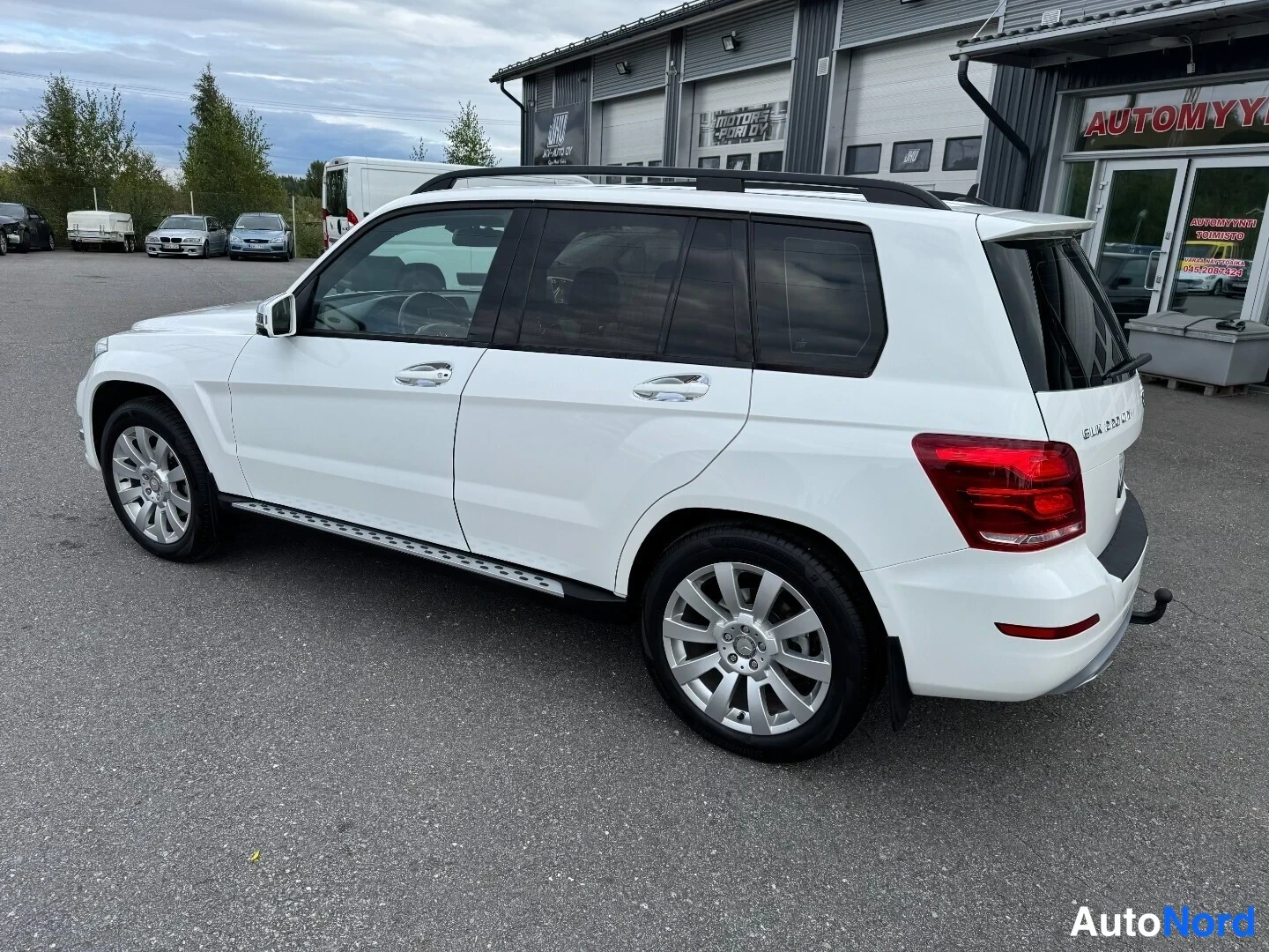 Takaviisto: Valkoinen Mercedes-Benz GLK takaa-vinoon kuvattuna autotallin edessä.