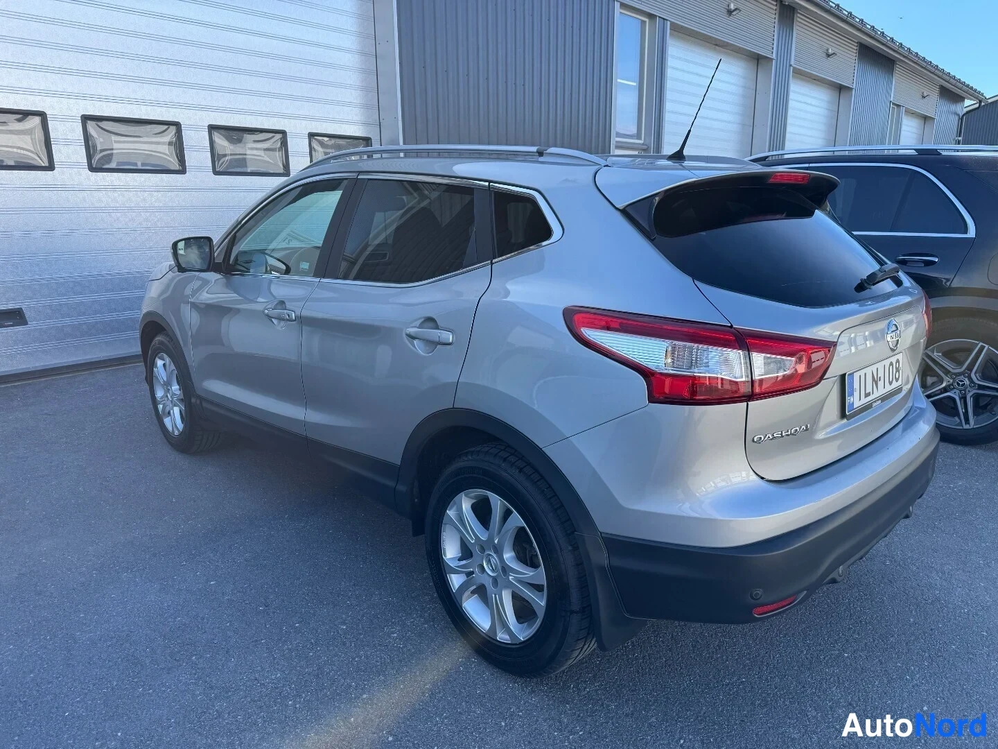 Takaviisto: Hopeanharmaa Nissan Qashqai takalistoilta vasemmalta kuvattuna, takavalot ja rekisteritunnus näkyvät.
