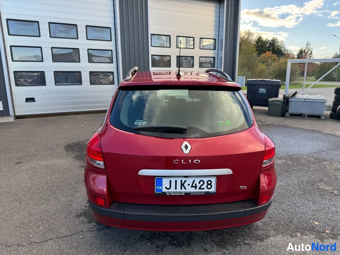 Takaa: Punaisen Renault Clion takaosa suoraan takaa, rekisterikilpi ja CLIO-merkintä.