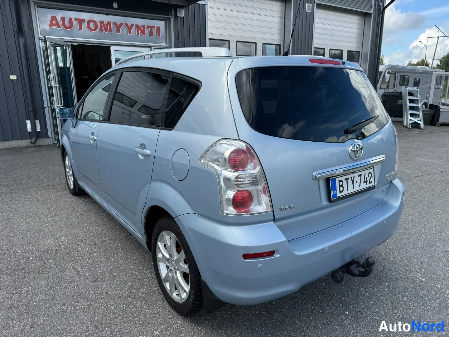 Takaviisto: Toyota Corolla Verso takaa viistosti oikealta, vaaleansininen koritila ja kirjainlevy.
