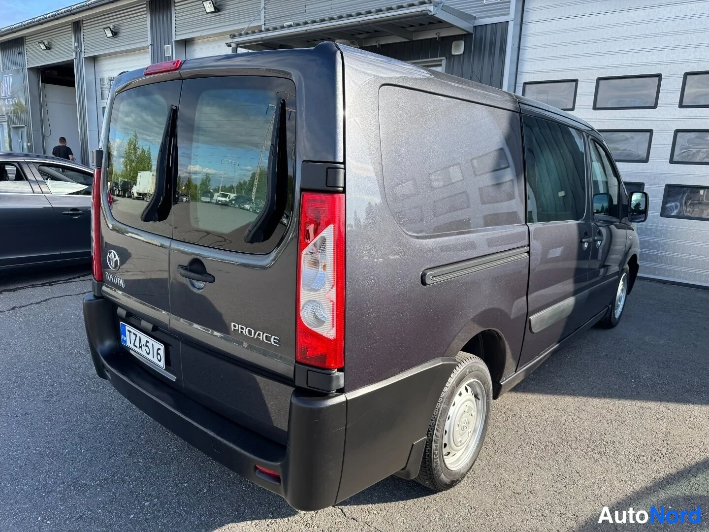 Takaviisto: Tummanharmaan Toyota Proace -pakettiauton takapää ja oikea kylki takaviistosta kuvattuna.