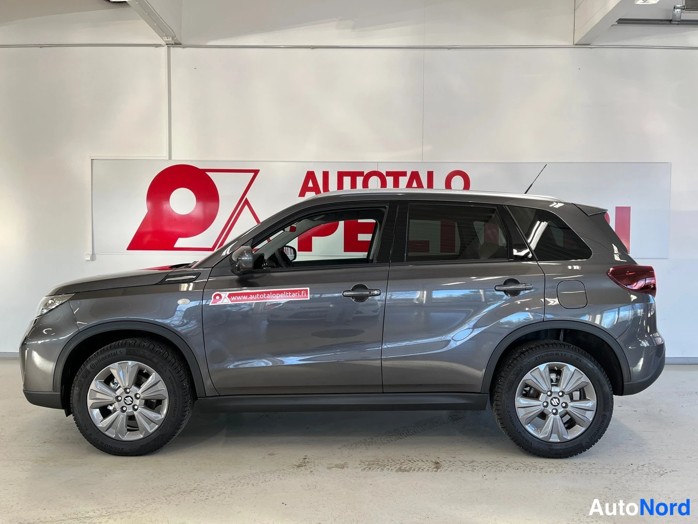 Sivulta: Suzuki Vitara -maasturin sivukuva oikealta puolelta sisätiloissa, auton koriväri tummanharmaa.