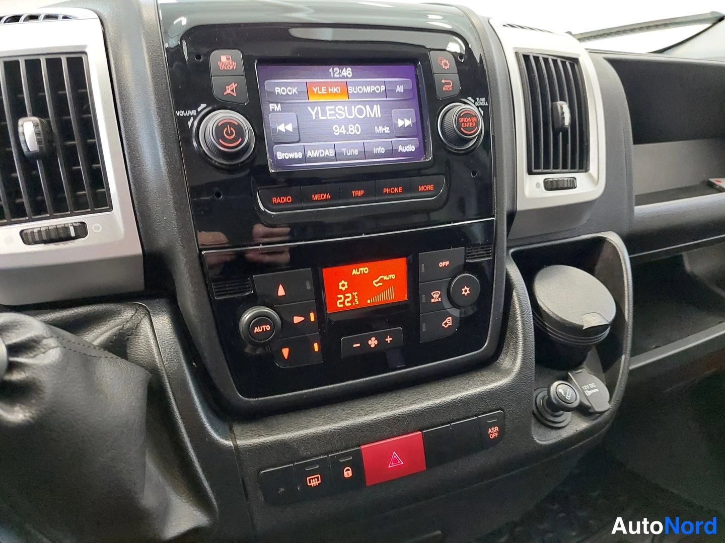 Muu: Automerkkien keskuspaneeli, jossa radiot näyttö, automaattinen ilmastointi (AUTO, 22 °C) ja alaotsikkopainikkeet RADIO, MEDIA, TRIP, PHONE.