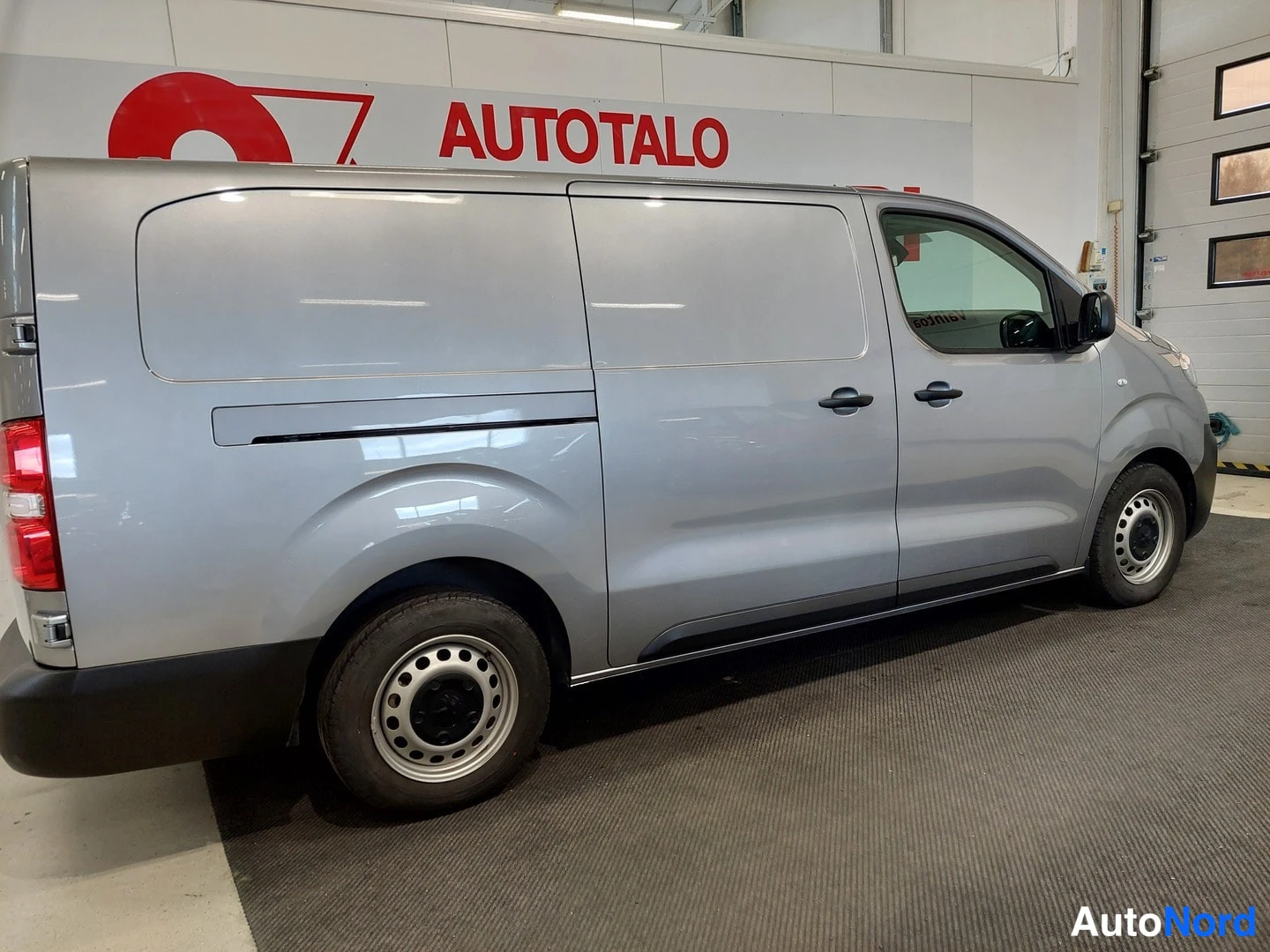 Sivulta: Pakettiauton sivunäyttö oikealta: hopeanharmaa Peugeot Expert, liukuovet ja mustat ovikahvat, teräsvanteet.