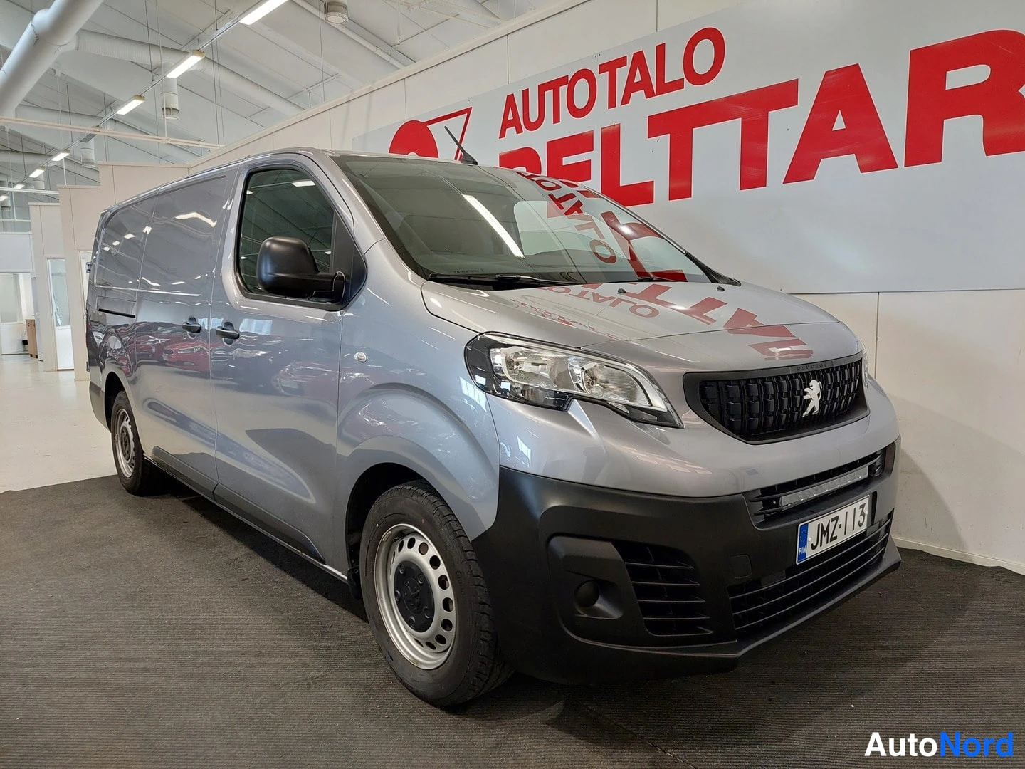 Etuviisto, nokka oikealle: Pakettiauton etukulmanäyttö: hopeanharmaa Peugeot Expert, tumma etusäleikkö, LED-päivätulet puskurissa, rekisteri.