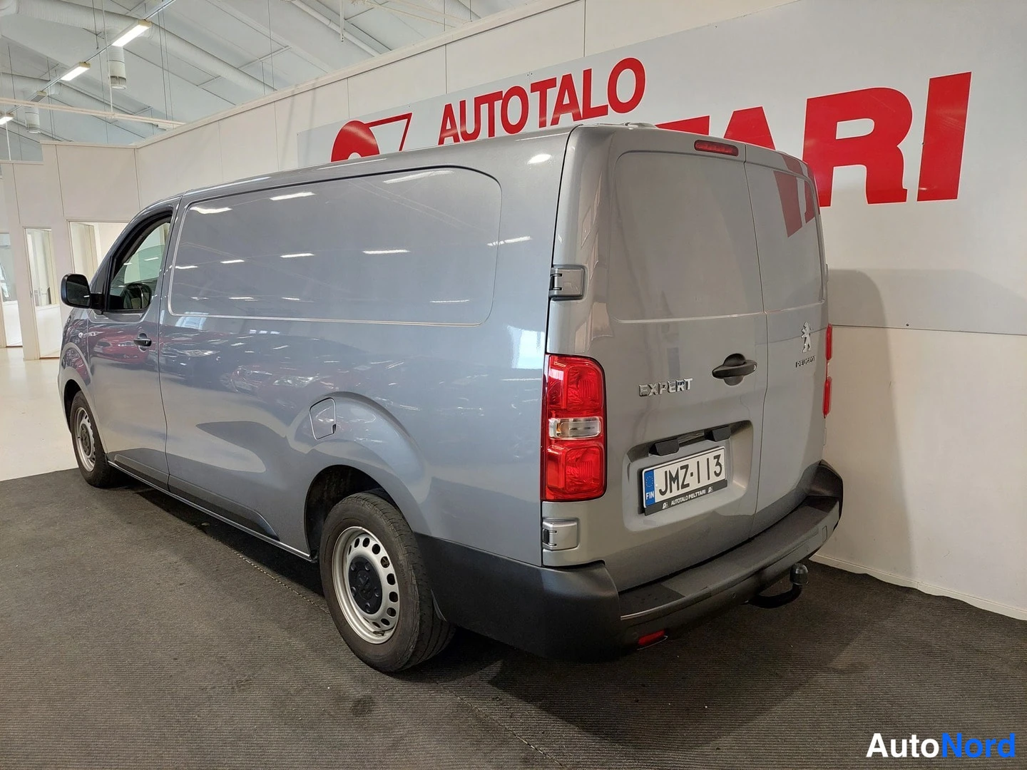 Takaviisto: Pakettiauton takakulmanäyttö vasemmalta: hopeanharmaa Peugeot Expert, takaluukussa Expert-merkintä, punaiset takavalot, rekisteri.