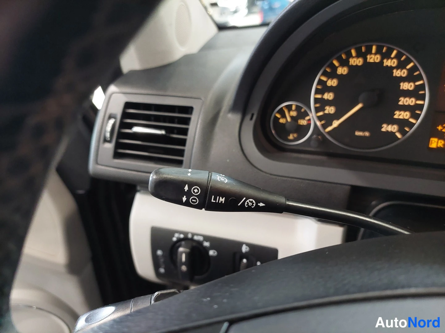 Yksityiskohta: Ohjaustangon cruise control -vatkain ja kojelaudan nopeusmittari