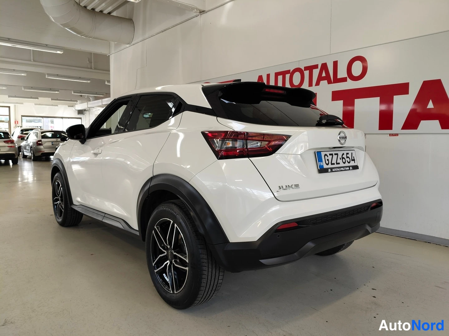 Takaviisto: Nissan Juke takakulmanäyttö, takavalot ja rekisteritunnus näkyvissä.