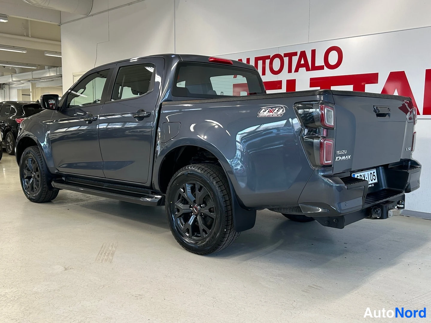 Takaviisto: Isuzu D-Max -avolava-auto takaa oikeasta kulmasta, tummanharmaa kori ja mustat vanteet.