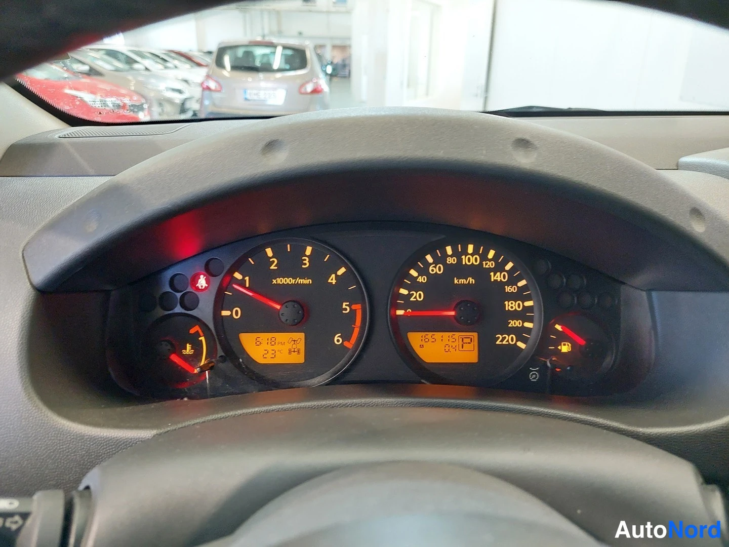 Yksityiskohta: Mittariston lähikuva: nopeusmittari asteikolla 20–220 km/h, kierroslukumittari, polttoainemittari matala ja odometerissa luku 165145 km.