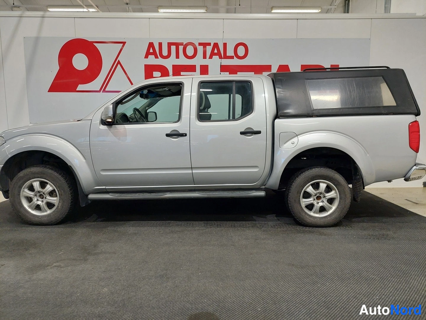 Takaviisto: Nissan Navara - kaksoismittarit takaosa oikealta, hopeisenä; kuormaan asennettu tumma kuorasuoja.