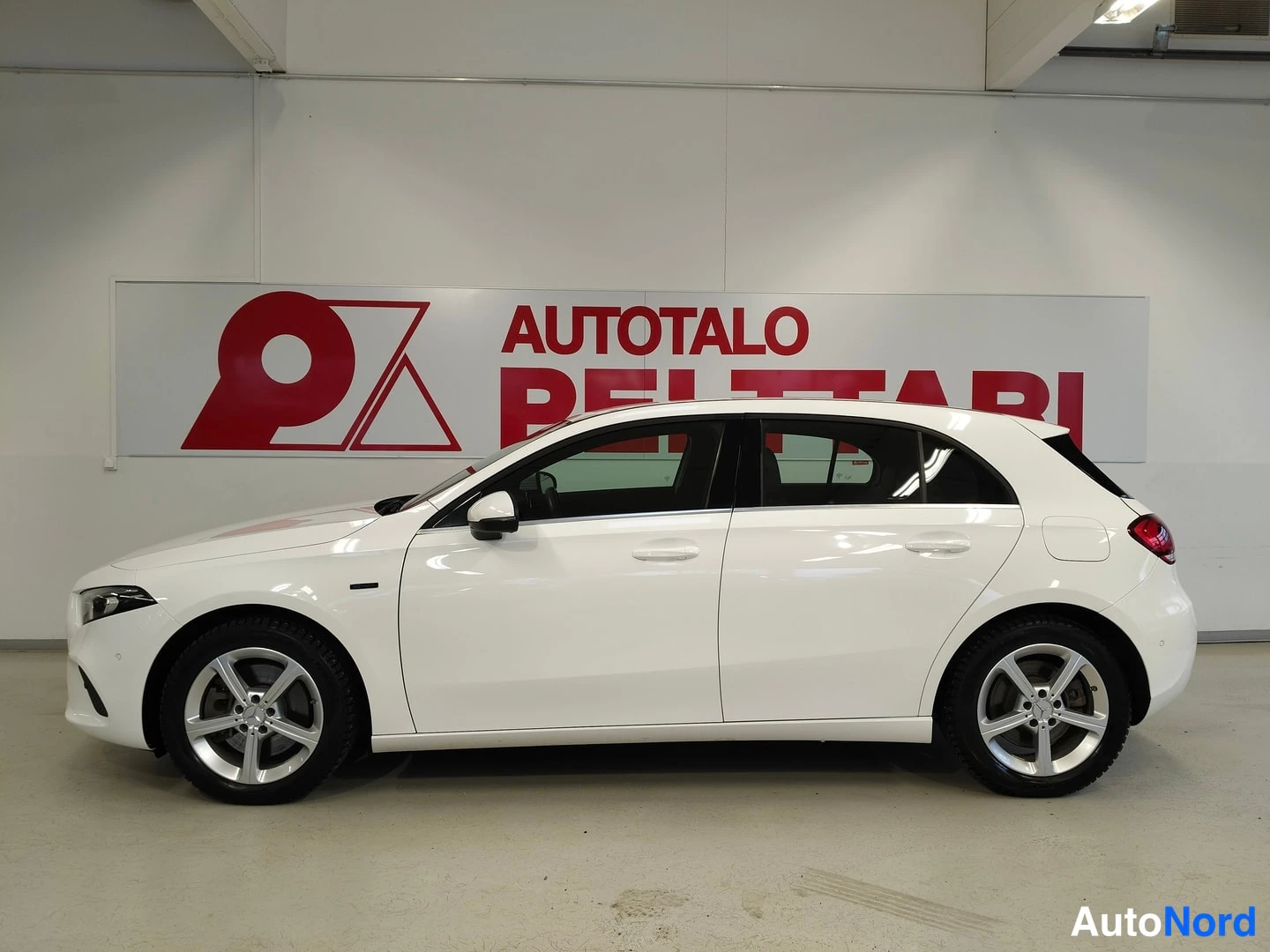Sivulta: Mercedes-Benz A -mallin sivunäkymä vasemmalta, valkoinen viisiovinen hatchback.