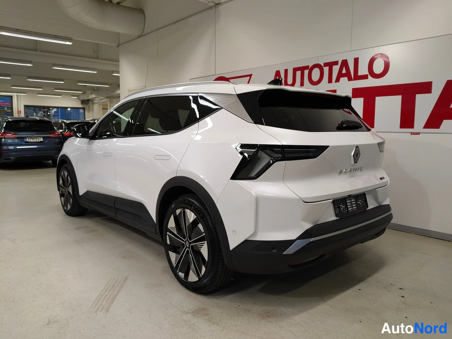 Takaviisto: Renault Scenicin takaosa ja oikea sivu kolmannelta neljännekseltä, Scenic-teksti ja Renault-merkti takaovessa näkyvissä.