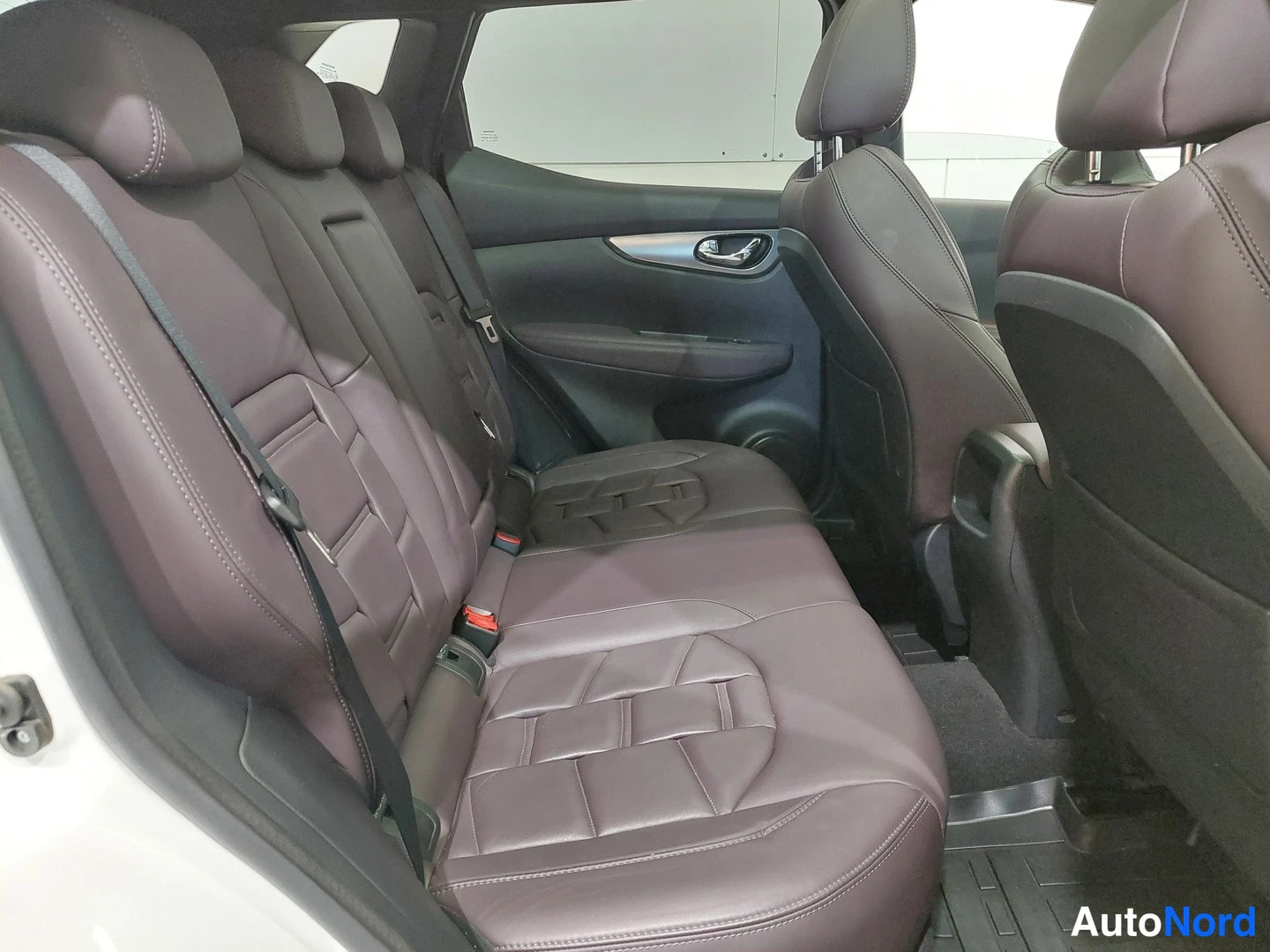 Muu: Nissan Qashqaiin takapenkin nahkapäällysteiset istuimet takaa oven aukosta katsottuna.